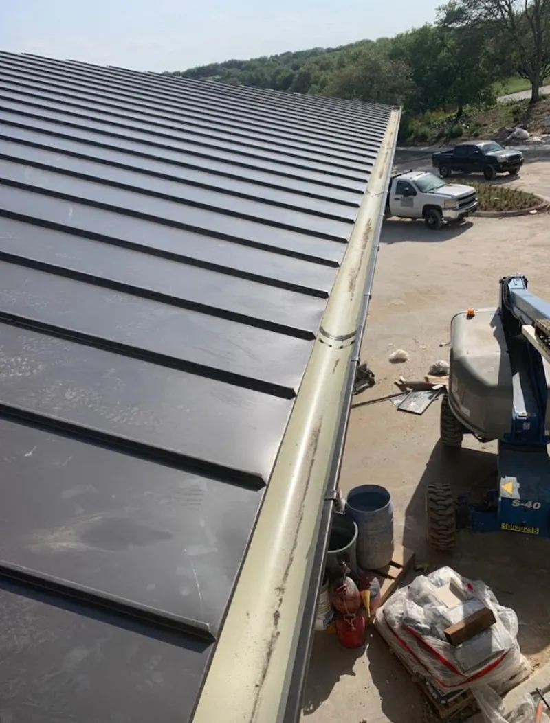 Standing seam panel and gutter detail on a metal roofing jobsite in Depew